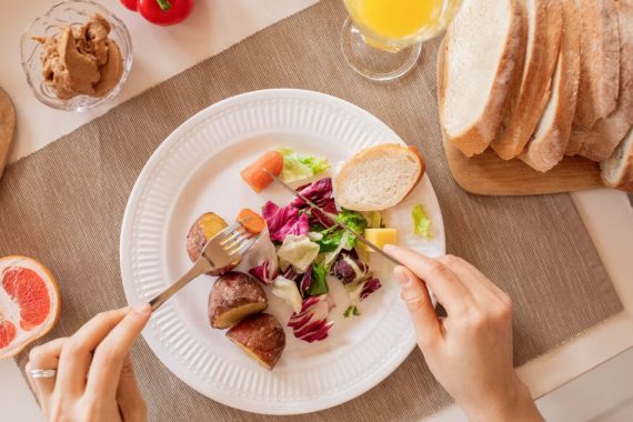 Top view of a nutritious breakfast setup with salad, bread, and fresh juice, perfect for a healthy start.